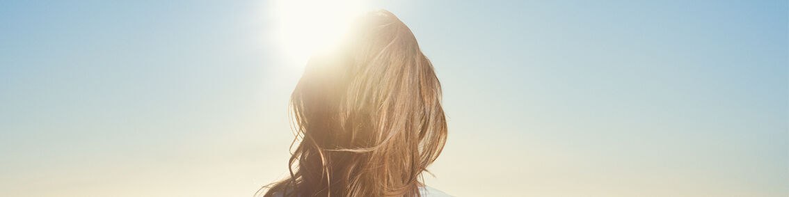 woman standing under the sun - L'Occitane